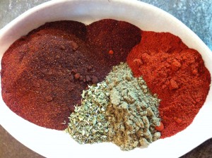 Clockwise from top: Chipotle Chile Powder; Paprika; ground Cumin; Mexican Oregano; Ancho Chile Powder.