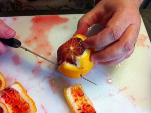 Cutting the peel off the oranges.