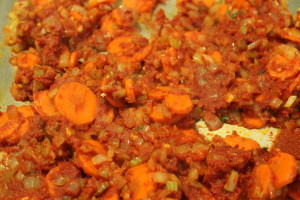 Adding the tomato paste. Let the paste cook until it begins to turn a burnt orange color. This is the sugar caramelizing and helps to deepen the flavor.