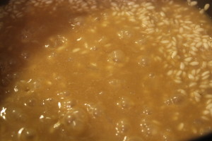 Adding the broth. Be sure to constantly stir the rice.