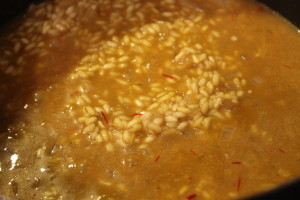 Adding the saffron broth. Now, the risotto will become its classic yellow color.